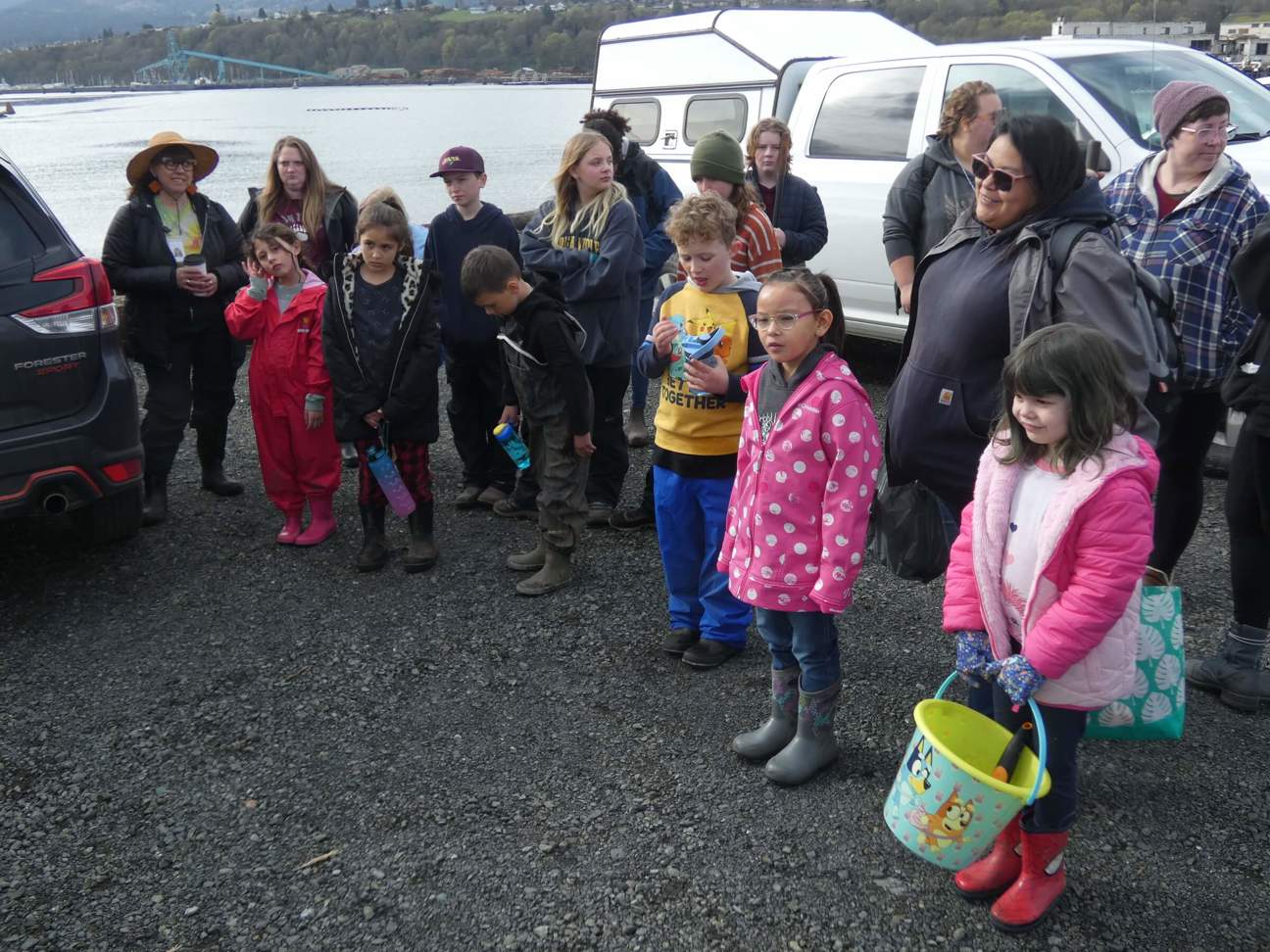 About a dozen children and chaperones cluster around listening to instructions for the day's planting